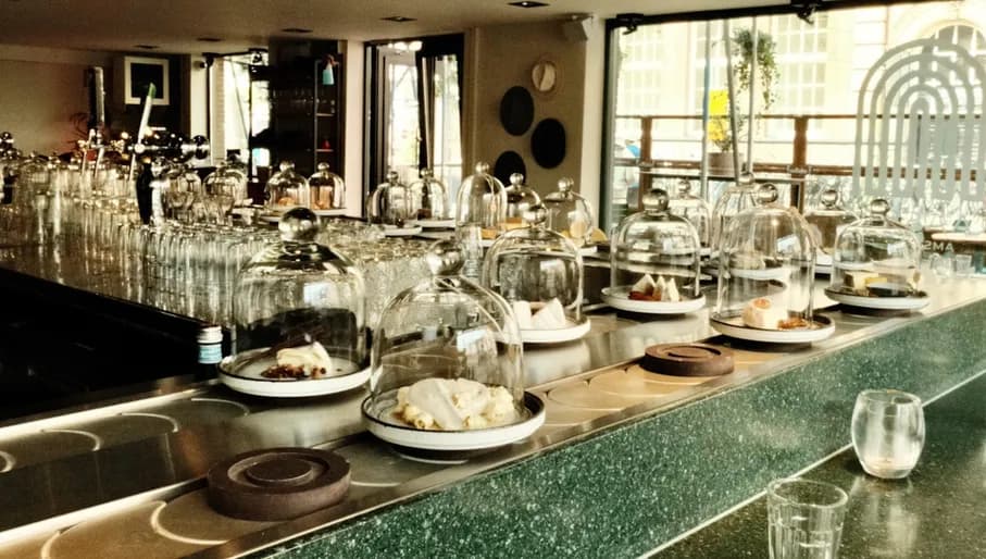 Kaasbar plates of cheese presented on conveyer belt