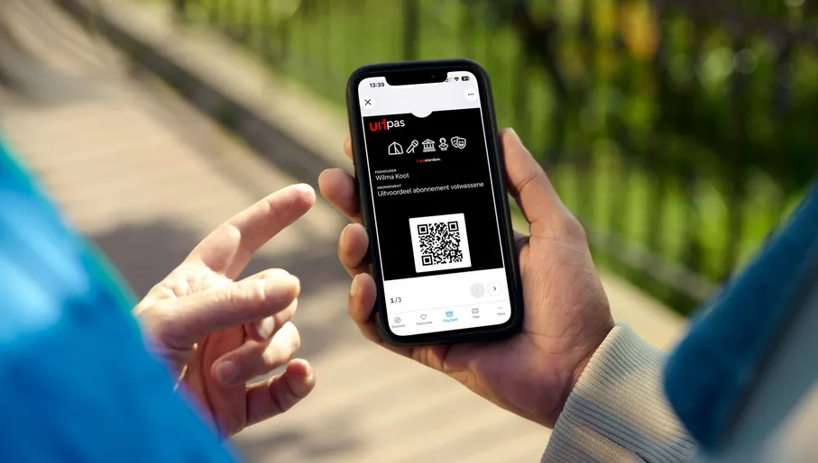 Closeup shot of the Uitpas app held by a person.
