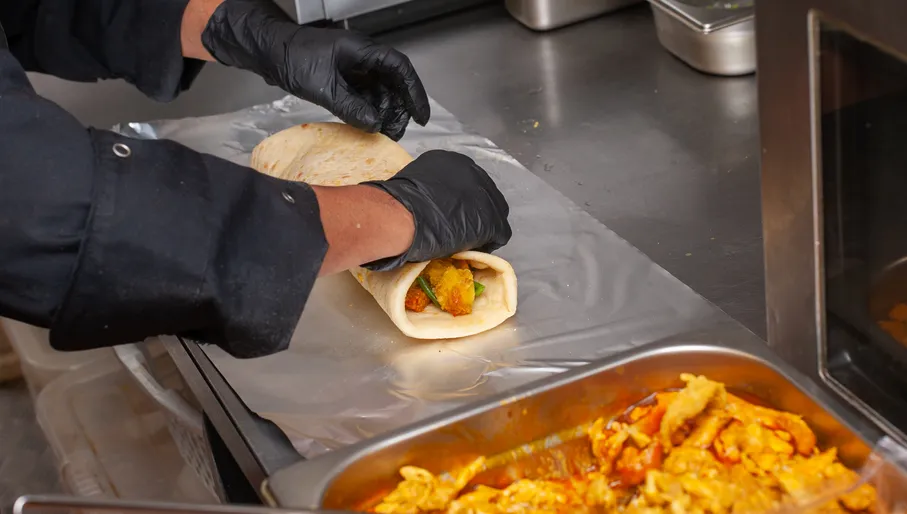 Chef preparing food at Rotishop Gieta