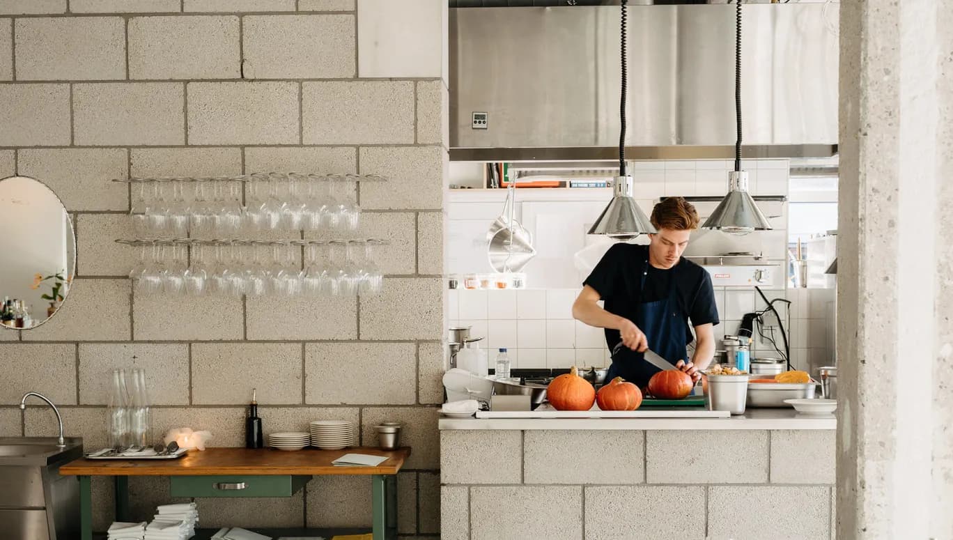 Chef chopping small pumpkin in kitchen at Cafe Restaurant Metro