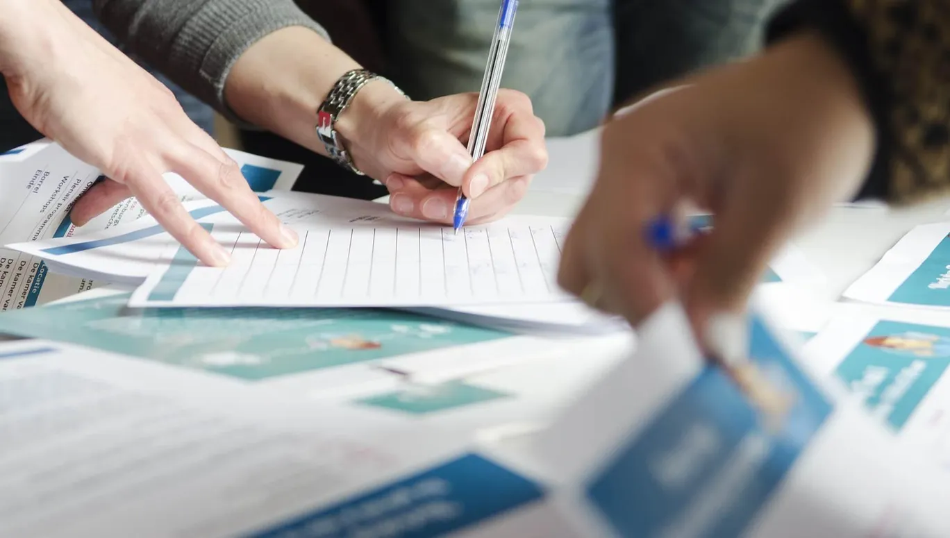 Close-up of hands going through stacks of forms