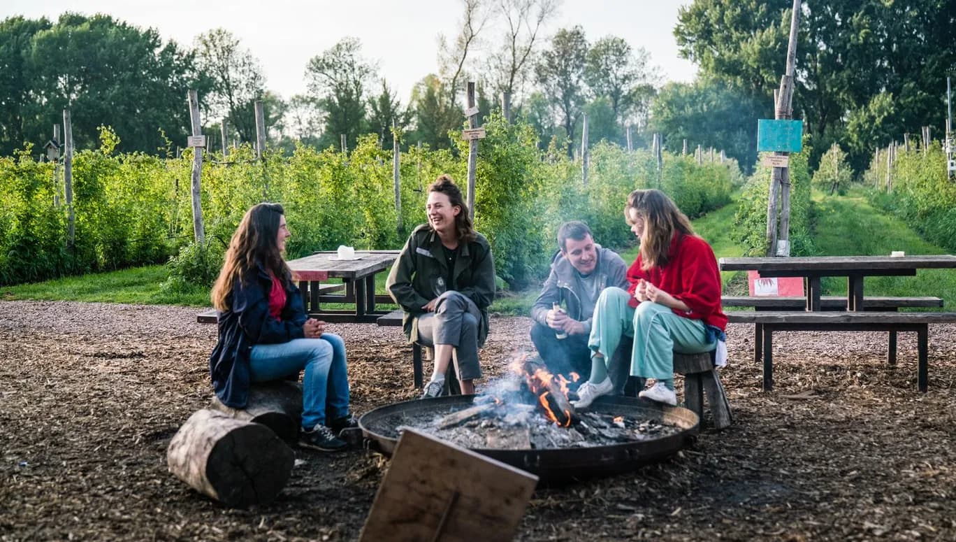 People sitting around the campfire at Fruittuin van West.