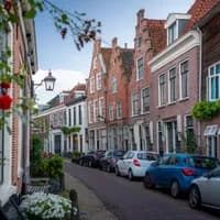 Authentic Haarlem street with parked cars and flowers on the walls.