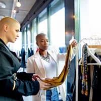 Two women looking at cloths at OSCAM x Closet Sale
