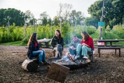 People sitting around the campfire at Fruittuin van West.