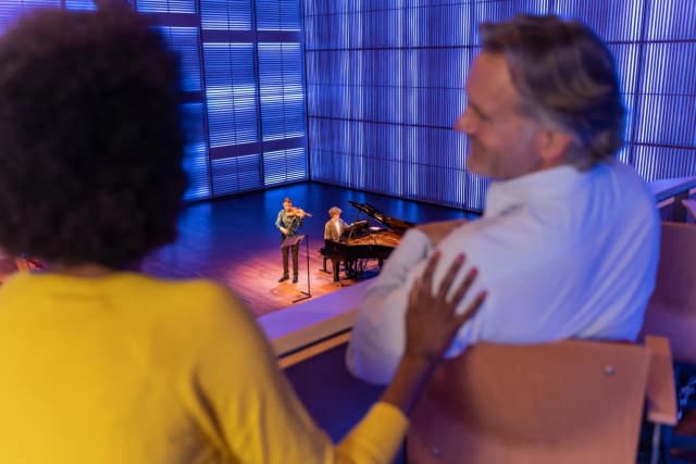 A couple enjoys a concert in het Muziekgebouw aan 't IJ.