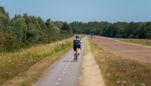A cyclist on De Knardijk. An inner dike that forms the border between eastern and southern Flevoland as a land divide.
