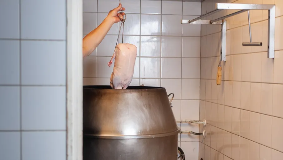 Chef frying duck in the kitchen at New Fusion roti shop Amsterdam