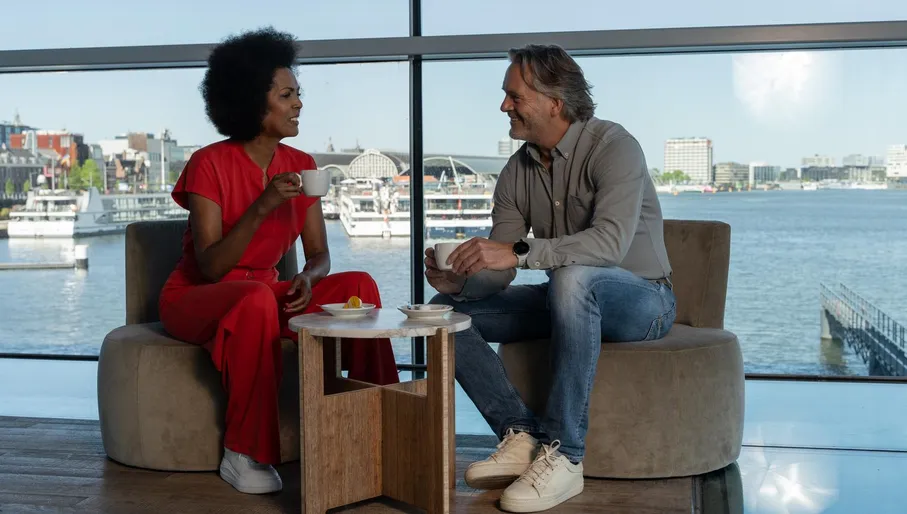 A couple drinking coffee in het Muziekgebouw aan 't IJ.