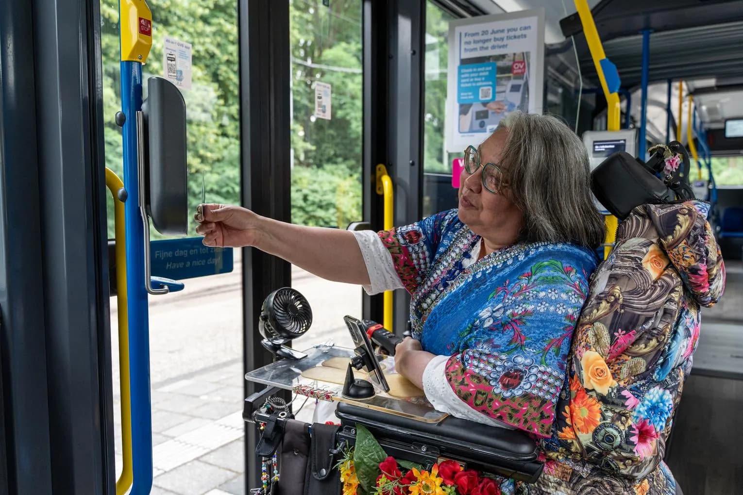 A person in an electric wheelchair in a bus checking-out.
