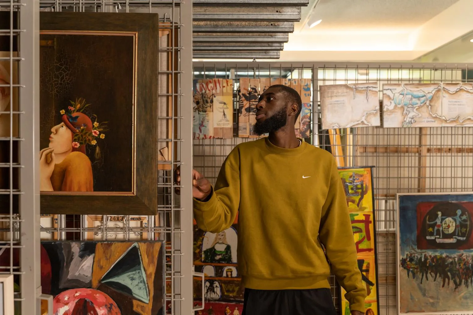 A man looks at the different paintings and drawings of the art loan of CBK Zuidoost.