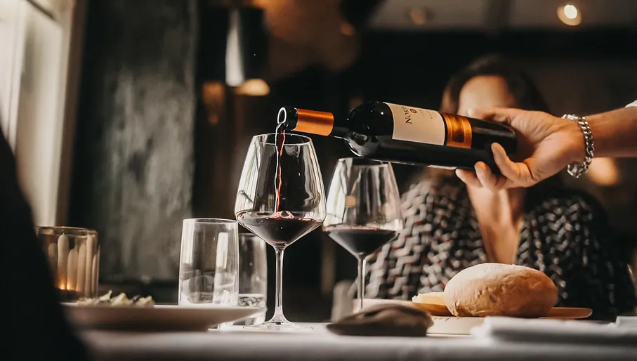 Waiter pouring wine at Jonge Dikkert restaurant
