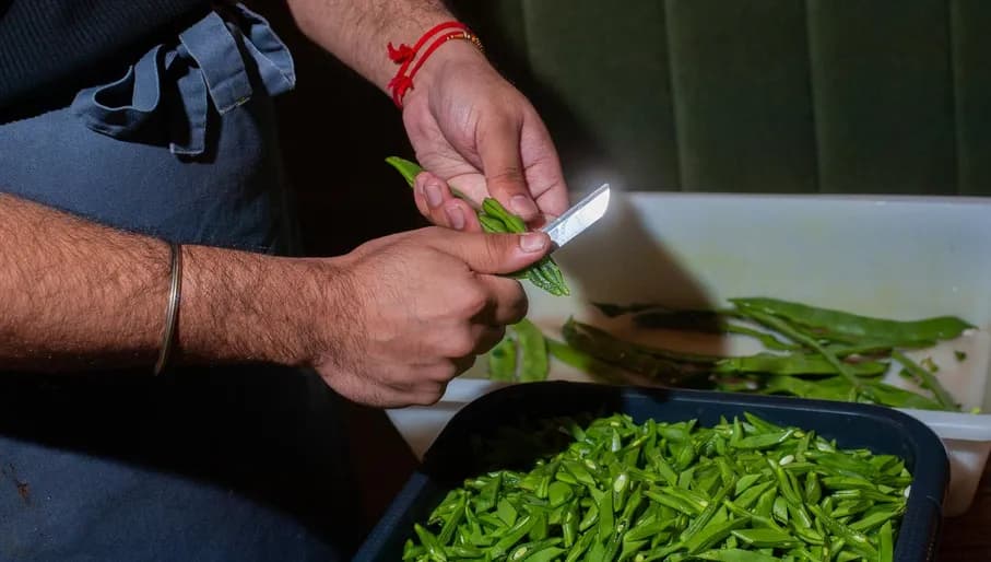 Chef chopping beans at Ricardos roti shop Amsterdam