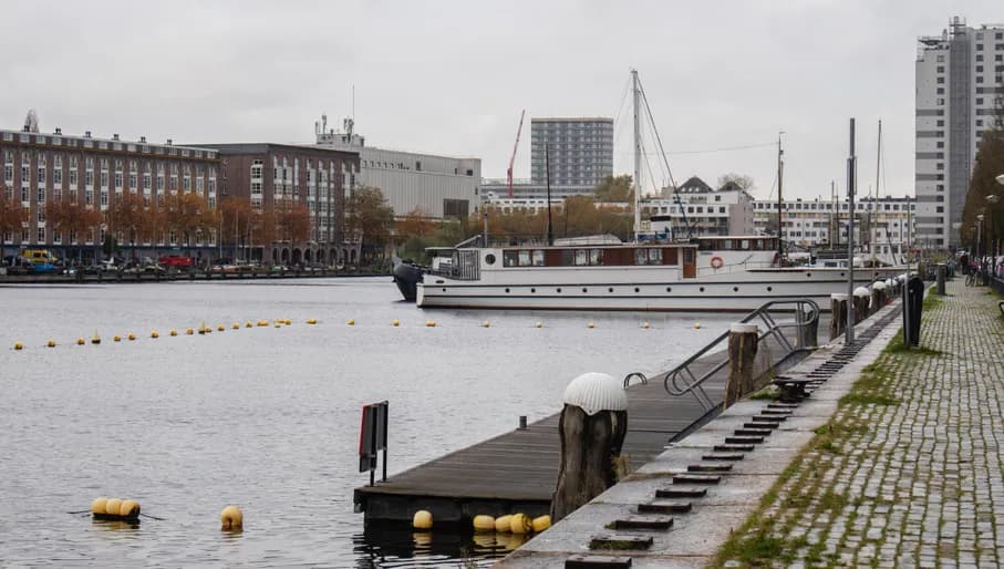 Oostelijk Havengebied water view in front of restaurant Oceaan. With a dok, boats and old warehouses in the back