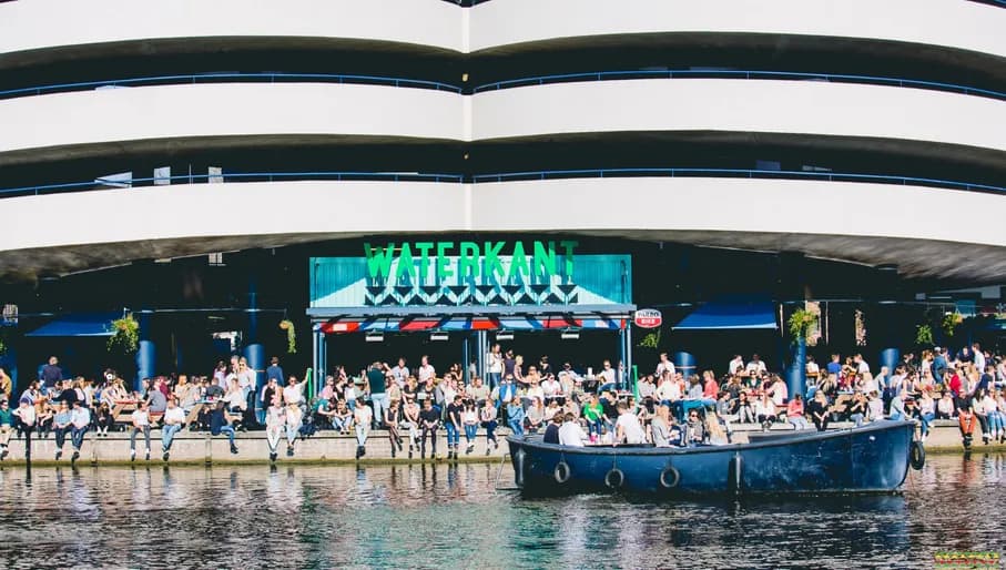 Waterkant people sitting outside and a boat passing by