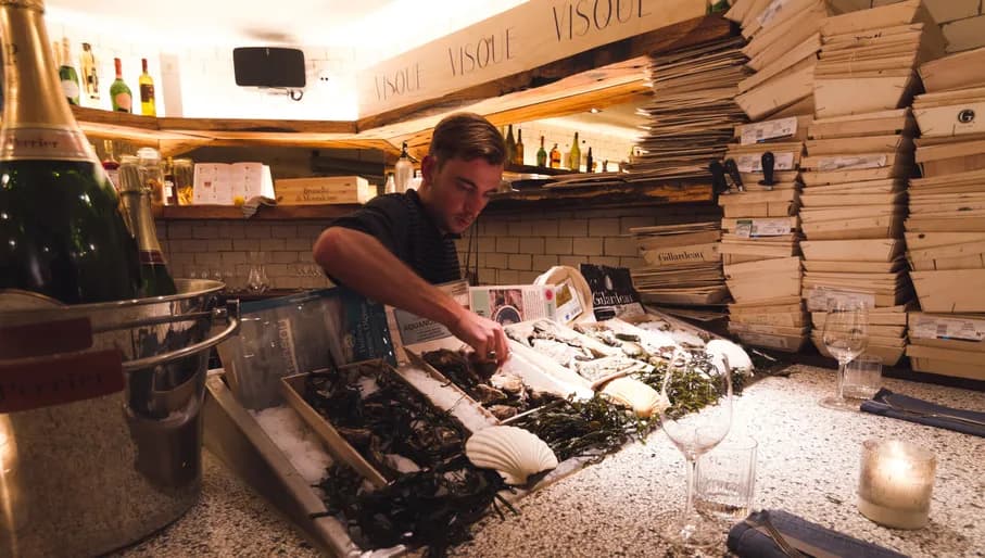 Kitchen assistant arranging the clam menu at Visque seafood restaurant