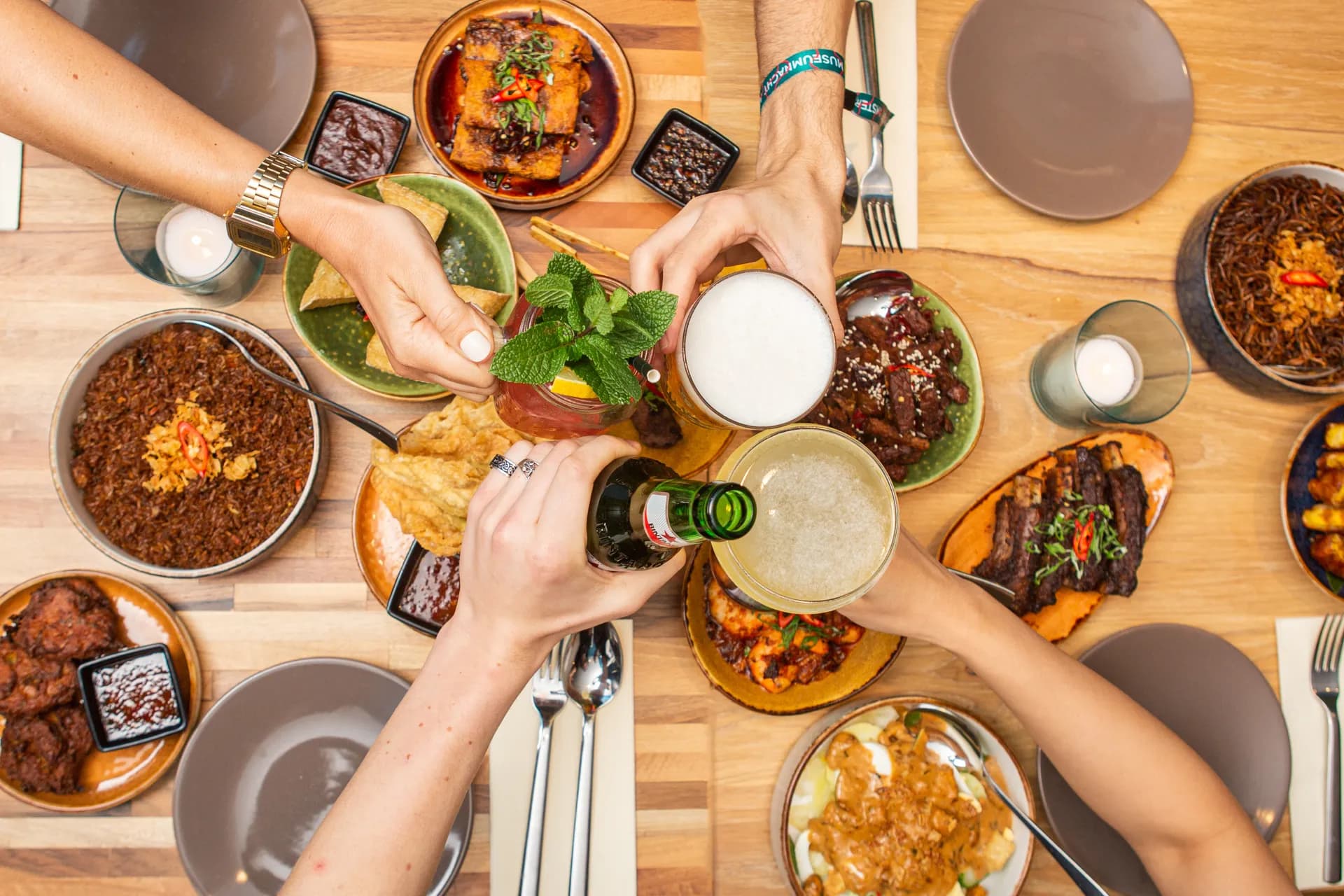People cheering over dishes at Warna Baru Indonesian restaurant
