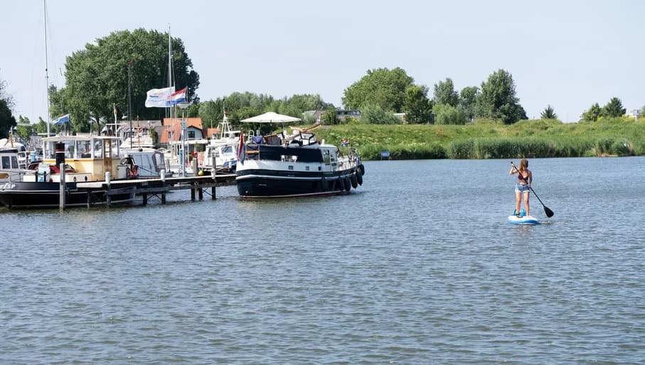 A woman on a stand-up paddleboard at the port @ Weesp