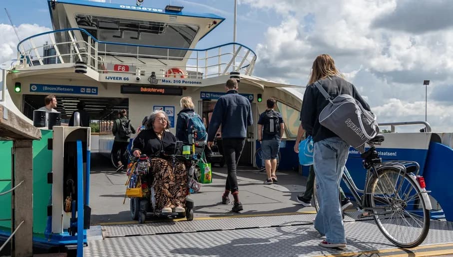 A person in an electric wheelchair exits the ferry.