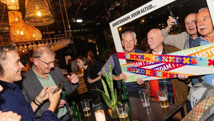 A group posing with a 750 Amsterdam frame at DGAQ