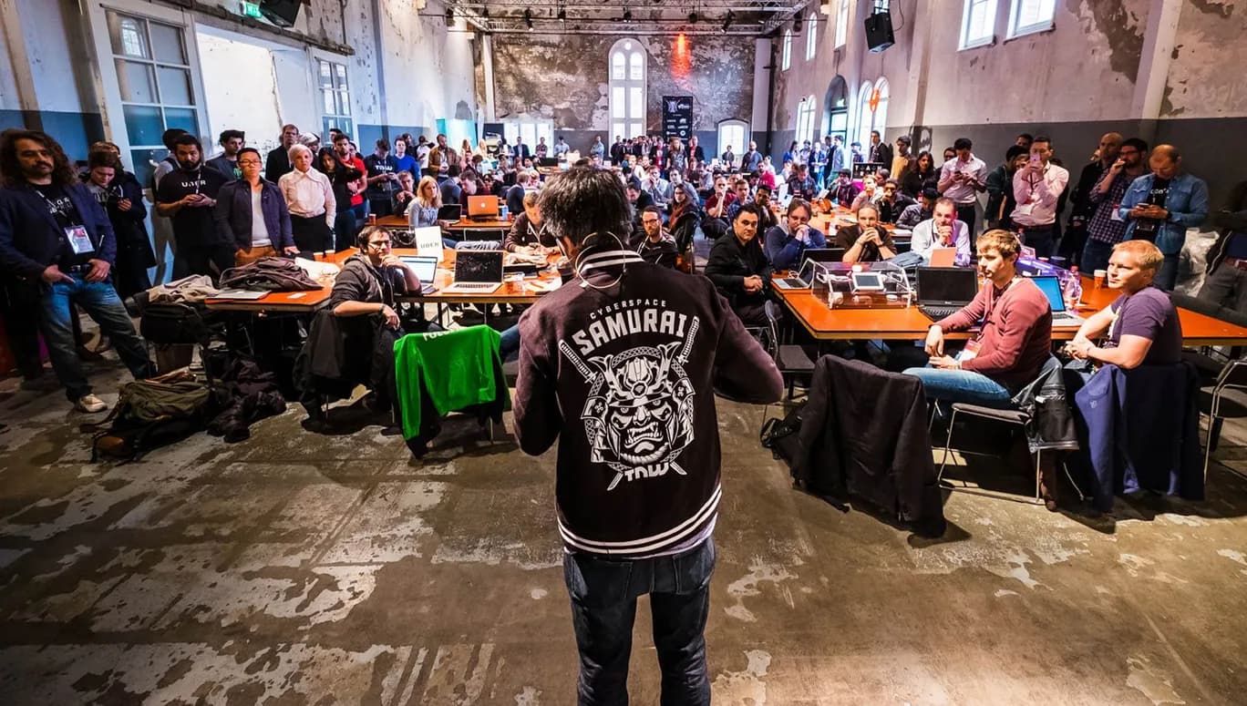Hack Battle 2016 speaker seen from behind people sitting down.