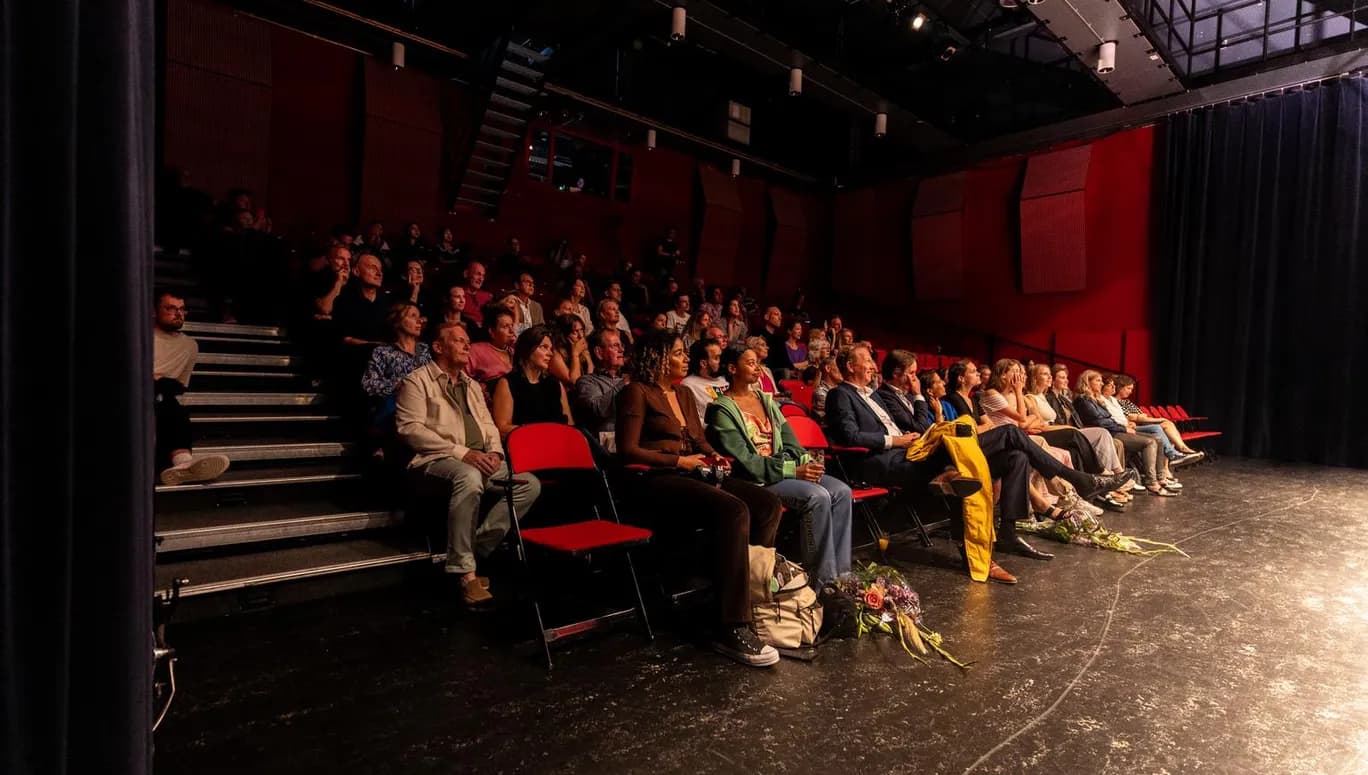 Theater De Landing, theater in Schouwburg Amstelveen, interior people sitting in the crowd on red chairs