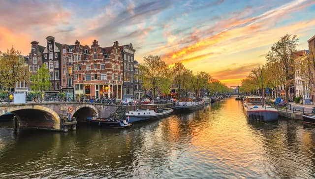 De Jordaan sunset and city skyline at canal waterfront.
