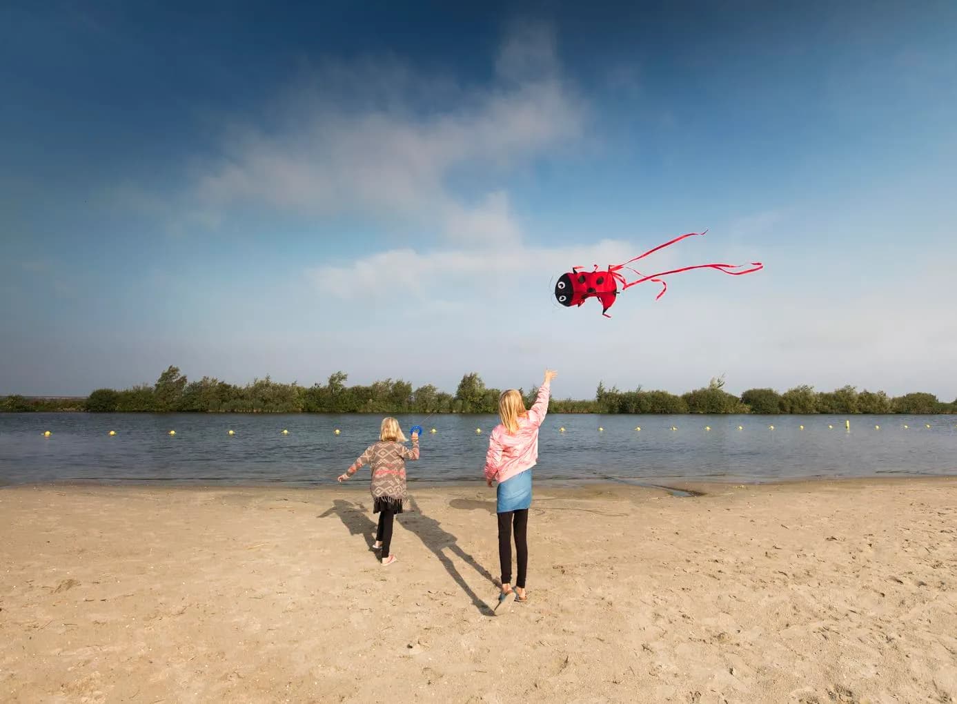 Kids flying a kite at the lake